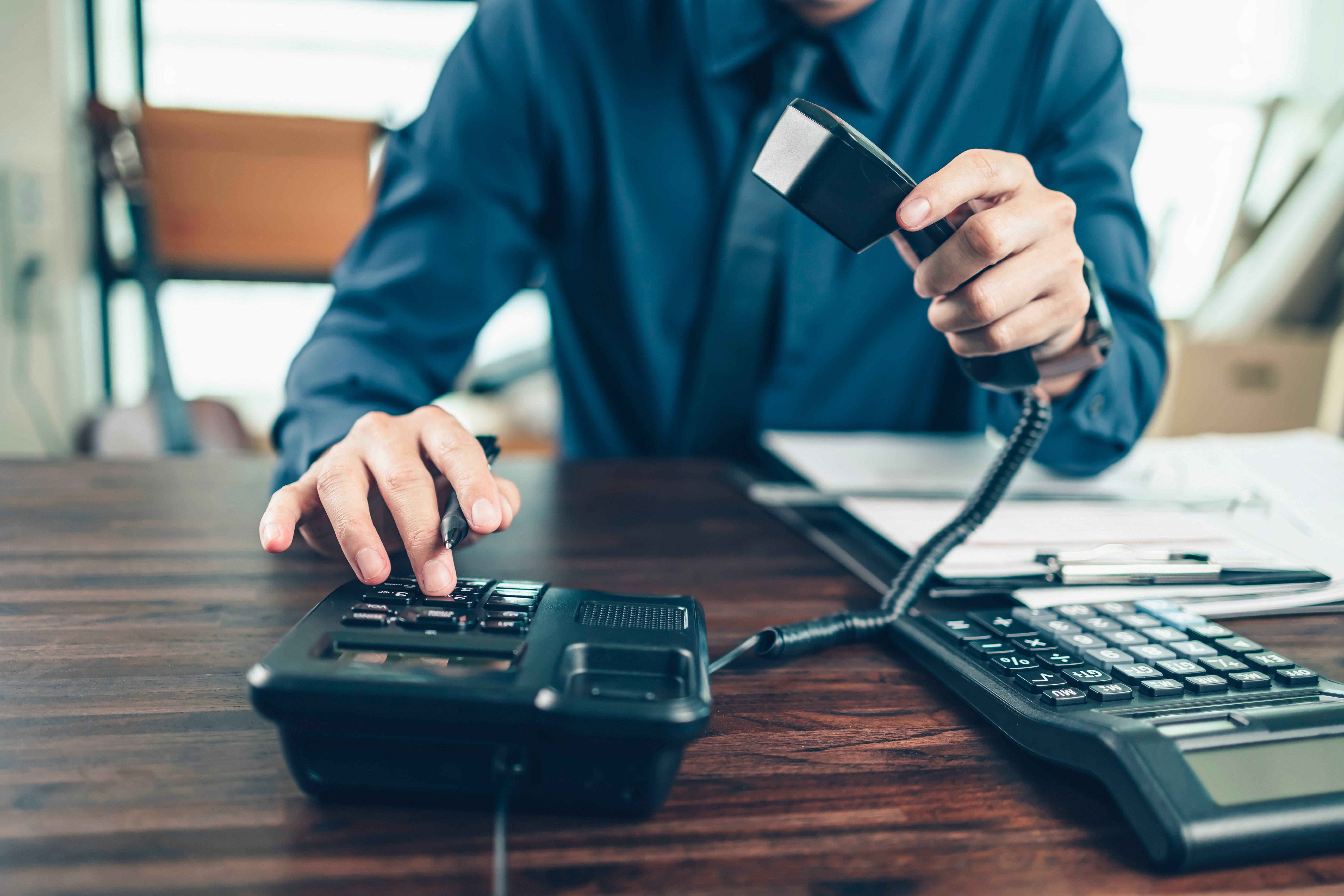 businessman dialing desk phone in the office. Telephone dialing ,contact and customer service.